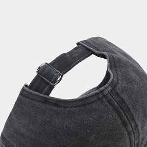 Detail of adjustable metal buckle and retro washed cotton texture on baseball cap