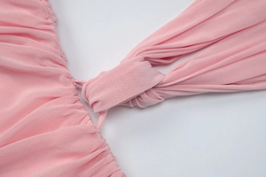 Detailed view of pink ruched fabric with intricate knot design and fine mesh texture