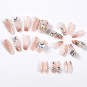 Detail of 24pcs pink gradient press-on nails with 3D bears, pearls, and rhinestones