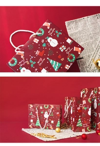 Detail view of red Merry Christmas gift bags with snowman and tree patterns on festive background