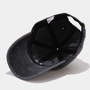 Washed dark grey cotton baseball cap showing internal stitching and adjustable strap