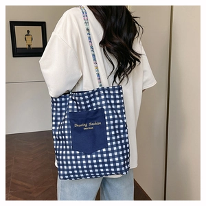 Detalle de un gran bolso tote de lona a cuadros azules y blancos en una modelo
