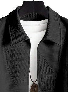 Detail of men's black jacket with 3D embossed geometric texture and lapel collar design