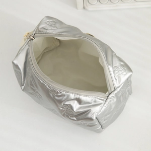 Detail of silver makeup bag showing embossed butterfly patterns and high-gloss PU texture