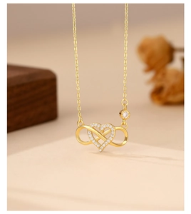 Macro shot of gold infinity heart pendant with micro-pave white cubic zirconia stones