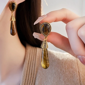 Macro shot of vintage teardrop earrings with tiger eye stone and crystal accents