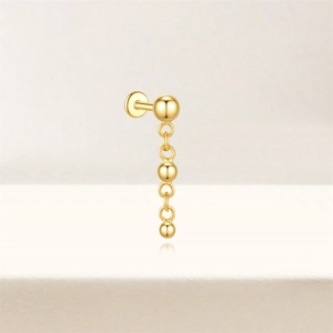 Detailed close-up of a gold-plated drop earring featuring hanging metal spheres