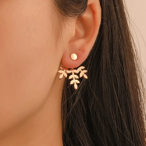 Detailed close-up of rose gold leaf earrings on ear, showing polished metallic texture