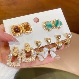 Detailed close-up of a 5-pair gold vintage earring set featuring pearls and resin