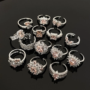 Adjustable silver flower rings set with pink champagne zirconia stones on black background