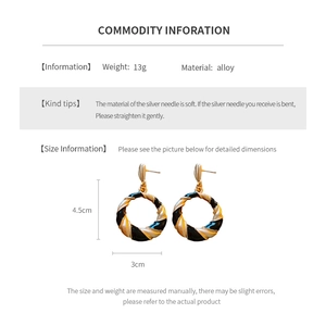 Detail showing dimensions of vintage twisted gold and black hoop earrings with silver needles