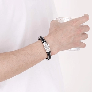 Dettaglio del bracciale in pelle intrecciata nera da uomo con chiusura ad ancora argento