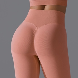 Detailed back view of high-waisted seamless peach lift leggings in coral pink rib fabric