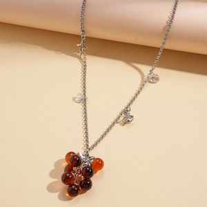 Detailed view of grape cluster pendant with amber resin beads and silver chain