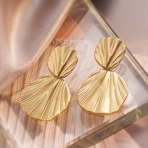 Golden double layered geometric fan shaped drop earrings on elegant champagne silk