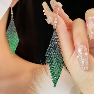 Détail de boucles d'oreilles losanges à franges en dégradé de vert et bleu serties