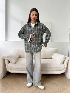 Detail of grey-green plaid shirt featuring elegant beige lace stitching on the cuffs