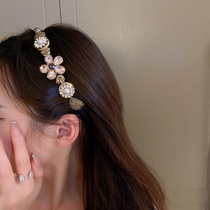 Close-up of elegant floral headband with rhinestones, pearls and golden leaves detail