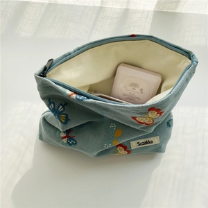 Detail of blue denim cosmetic bag with butterfly embroidery and Sozakka brand label