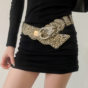 Macro shot of leopard print leather belt with crystal butterfly buckle and rhinestones