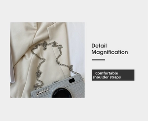 Detail of silver camera-shaped handbag with sequins and metal chain on a blazer