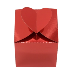 Détail de la fermeture en forme de cœur rouge métallique sur une boîte cadeau