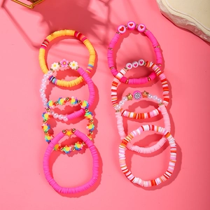 Close-up of colorful polymer clay heishi bead bracelets with floral and heart charms