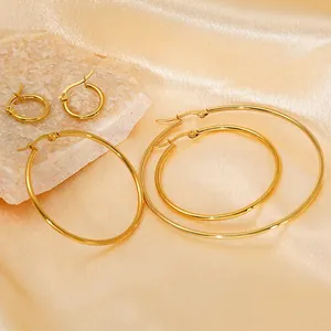Set of four 18K gold plated stainless steel hoop earrings on silk and stone display