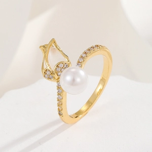 Macro shot of 18K gold tulip ring with sparkling zircon pavé and a large white pearl