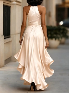 Detail of elegant satin champagne gold dress with backless design and irregular hemline