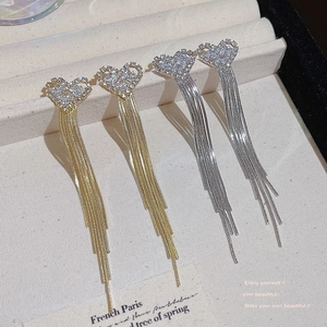 Elegant heart-shaped tassel earrings in gold and silver finish with sparkling rhinestones