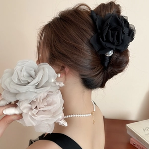 Détail de pinces à cheveux roses en tissu élégant avec perles en noir, gris et rose