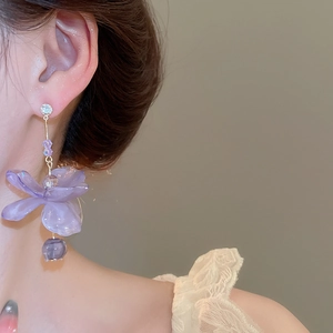 Close-up of lavender resin flower earrings with silver posts worn by a model