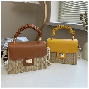 Detail of straw woven box bags with pleated handles and metallic twist lock closure