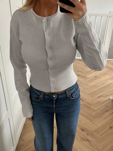 Détail du cardigan gris en maille montrant les poignets côtelés et les boutons