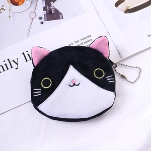 Detail of cute plush cat coin purse with pink ears and yellow embroidery on a white desk
