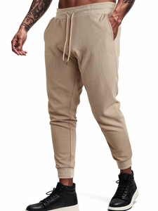 Detailed close-up of khaki waffle knit fabric texture on men's drawstring joggers