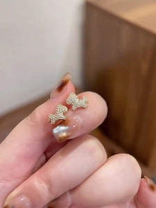 Detail of a gold plated unicorn earring with white cubic zirconia pavé stones