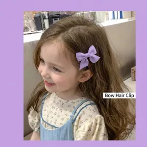 Cute purple fabric bow hair clip for girls shown on a child model with summer vibes