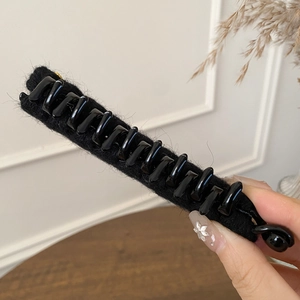 Macro detail of the black flocked banana hair clip with high-quality velvet texture