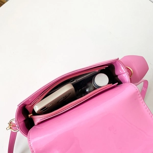 Interior view of bright pink patent leather crossbody bag showing spacious main compartment