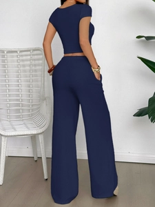 Elegant navy blue short sleeve knit top and wide leg pants set for women shown from back