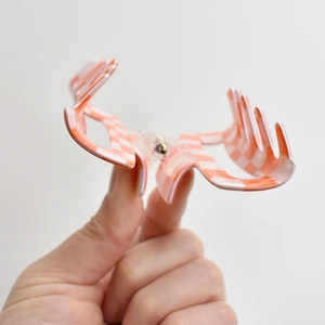 Detail showing the inner structure and orange-white checkered pattern of the hair claw