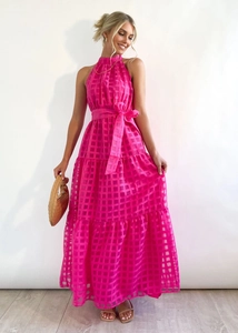 Detailed view of the tiered ruffle hem and pink plaid sheer fabric of the maxi dress