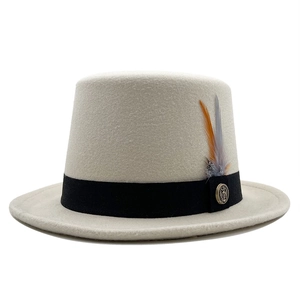 Detail of wool top hat featuring feather accent and vintage anchor metal badge