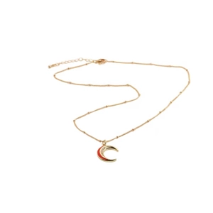 Dettaglio di una collana dorata con ciondolo a mezzaluna in smalto rosso e chiusura a moschettone