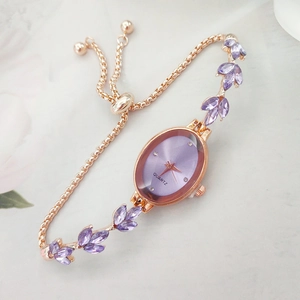 Elegant rose gold ladies watch with purple oval dial and crystal leaf charm bracelet