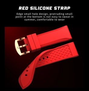 Detail of red silicone watch strap with breathable air holes and gold-tone metal buckle