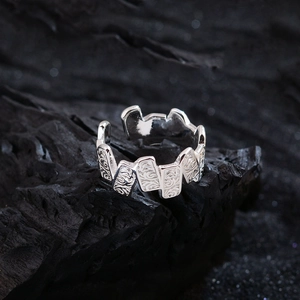 Silver retro engraved open ring with vintage floral patterns on a dark charcoal background