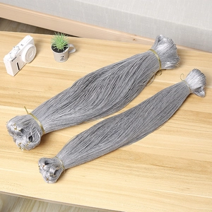 Cordón metálico plateado para envolver regalos y manualidades sobre mesa de madera
